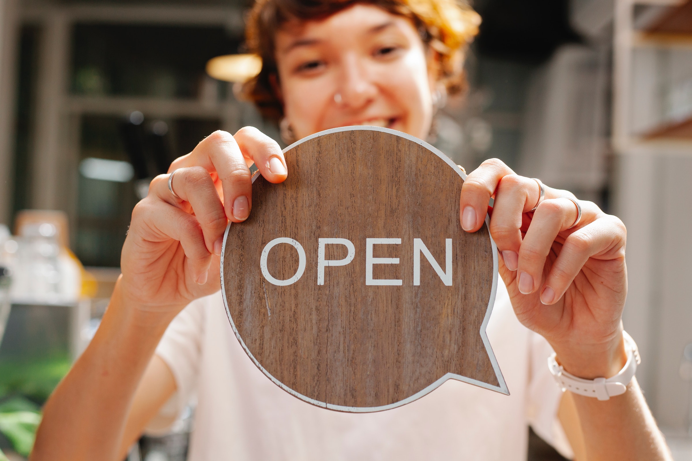 Preheader - lady with a wooden Open sign