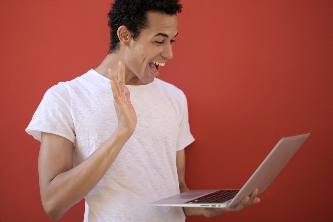 Man smiling at a computer happy to see his personalized email - Photo by Andrea Piacquadio - Pixels